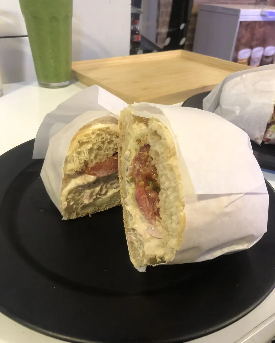 Sándwich de pollo en pan de masa madre con cebolla encurtida y tomate